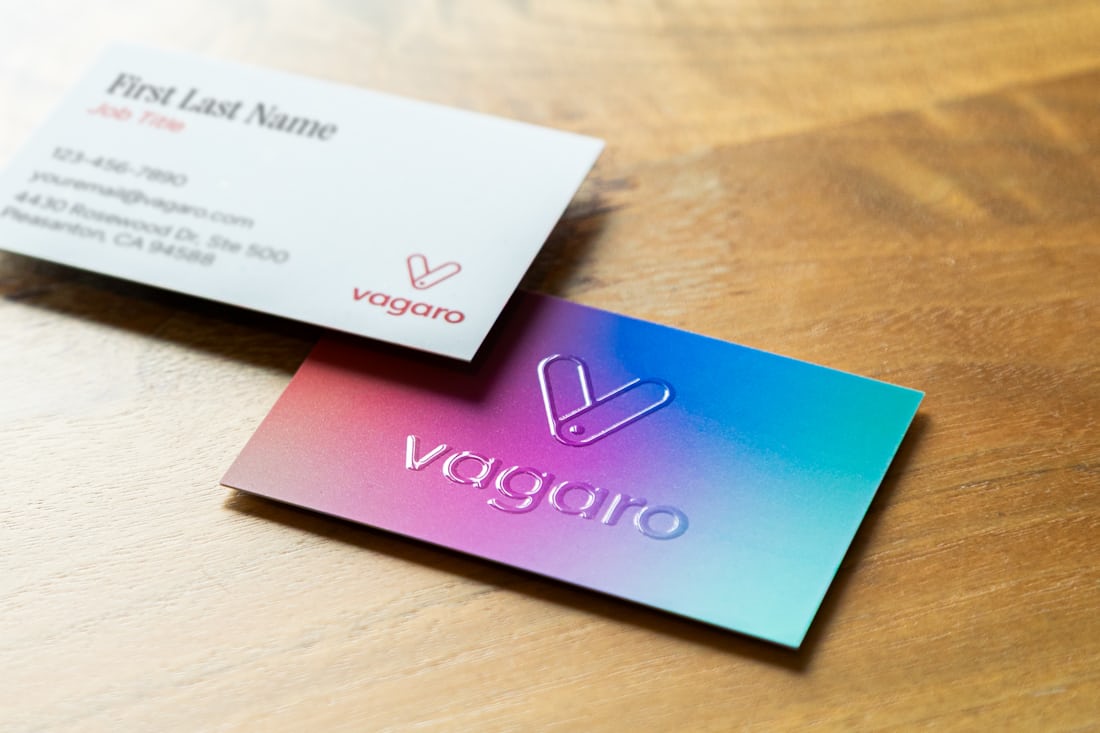 Tarjetas de visita con acabado en degradado sobre una mesa de madera